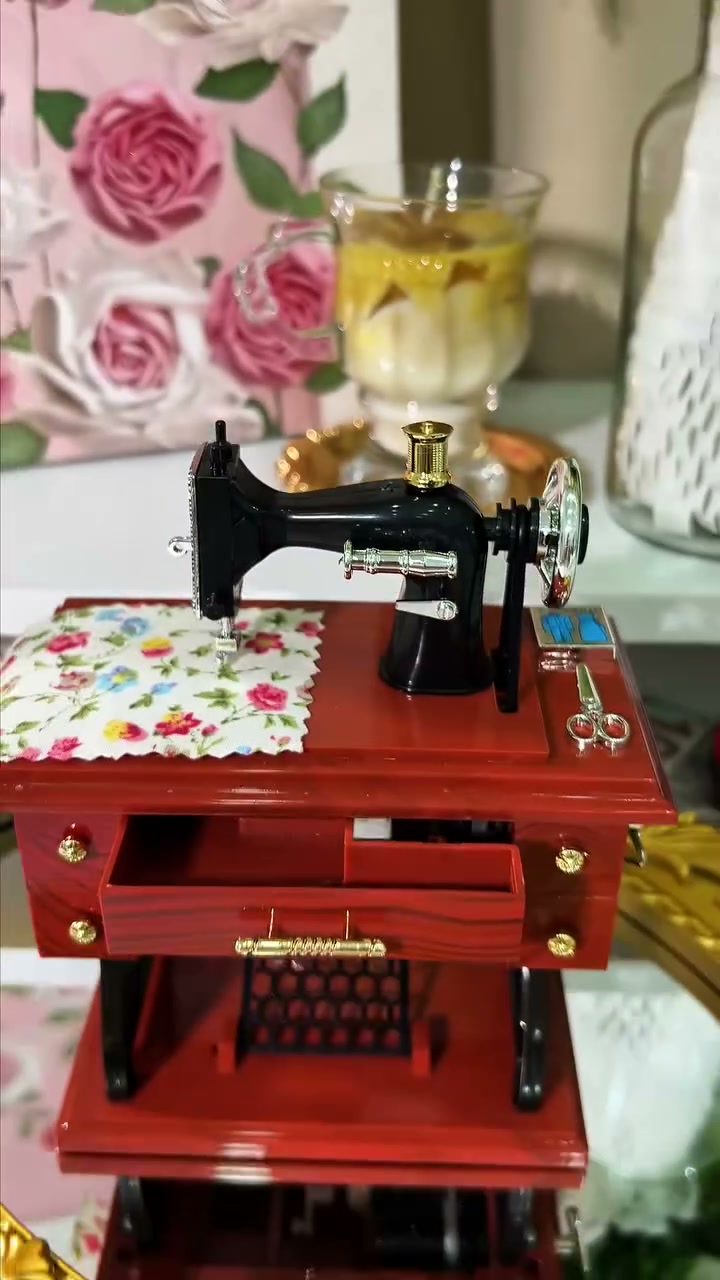Sewing machine music box on a gold mirror tray