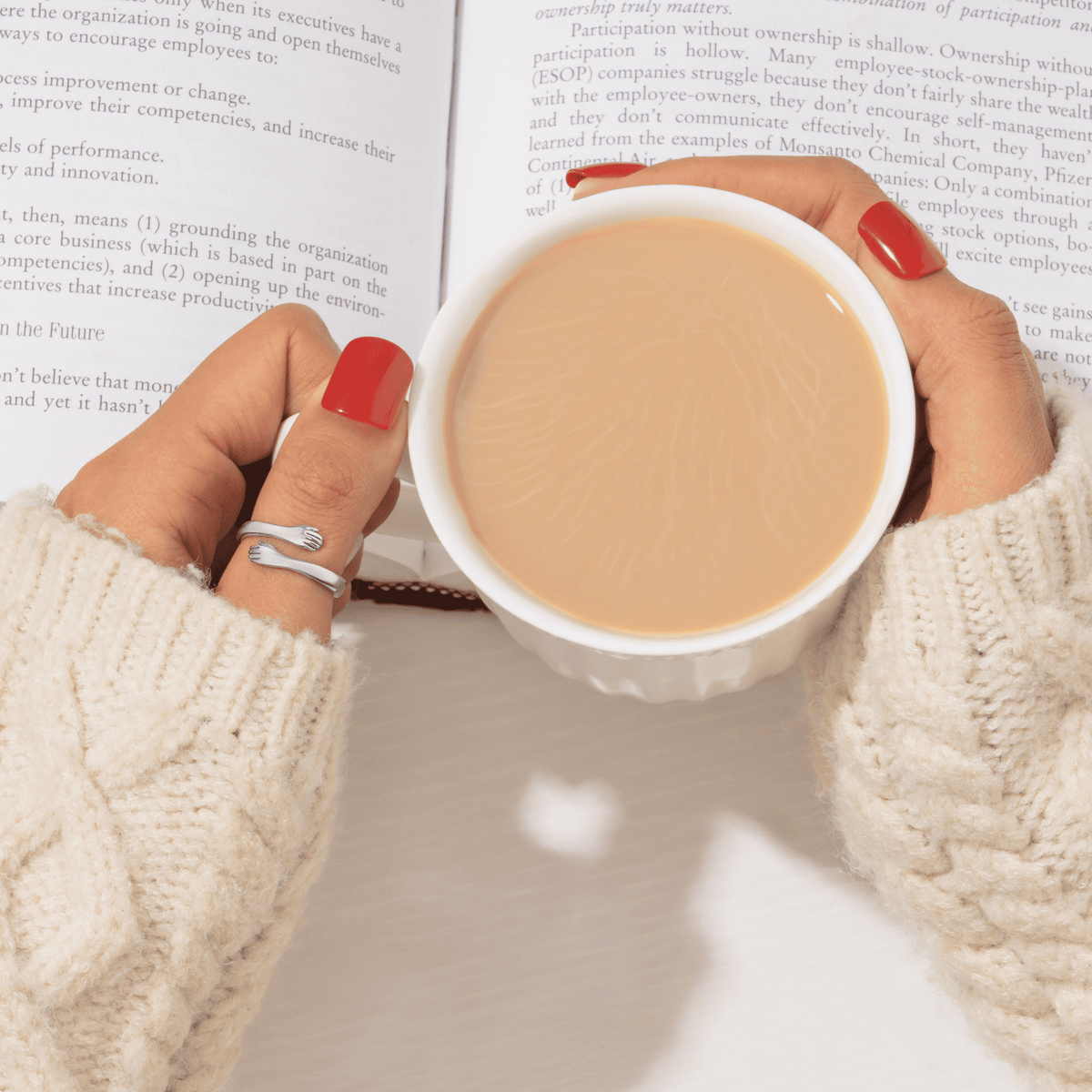 Huggi hug ring while holding a cup of coffee
