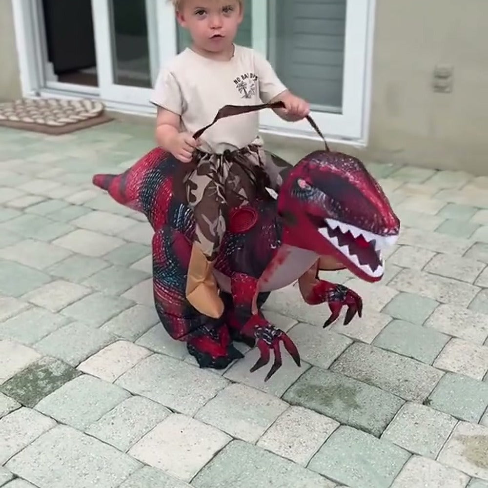 Child riding a red Raptie dinosaur costume on the patio