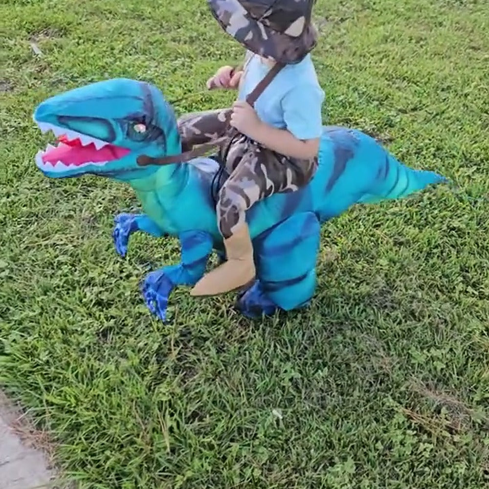 Child riding a blue Raptie dinosaur costume across the grass